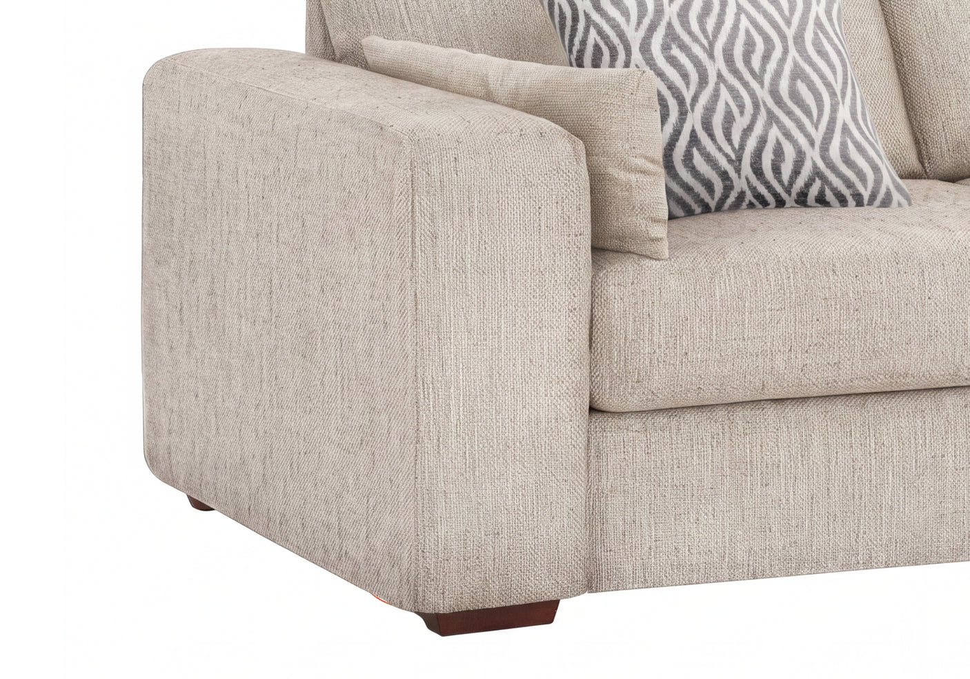 Close-up of a beige upholstered sofa corner with a patterned gray and white accent pillow on a white background.