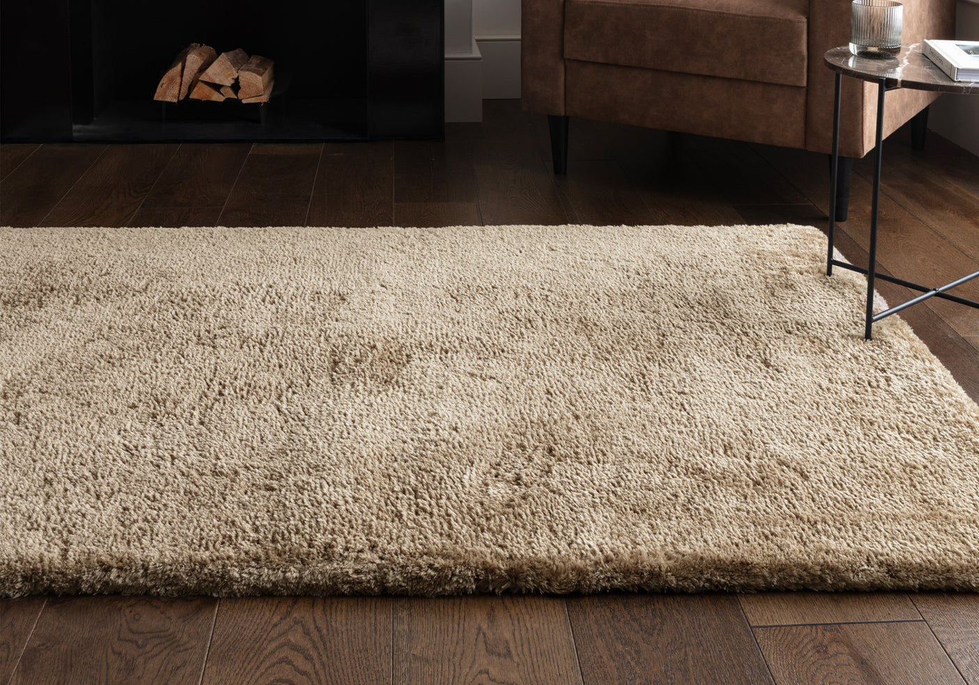 A taupe rug on a wooden floor.