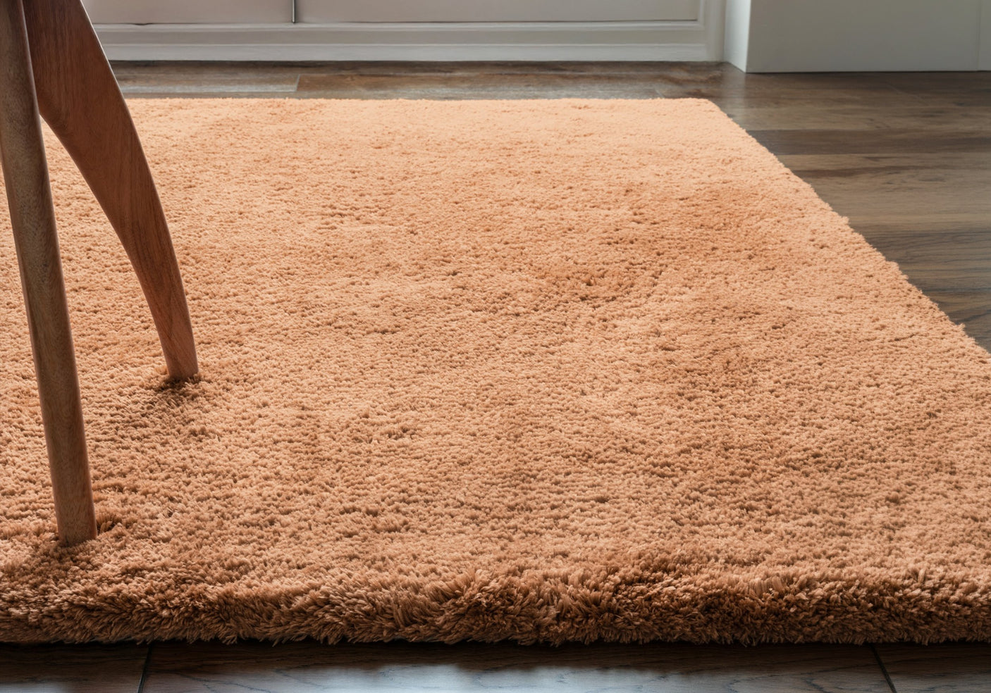 A terracotta rug on a wooden floor.