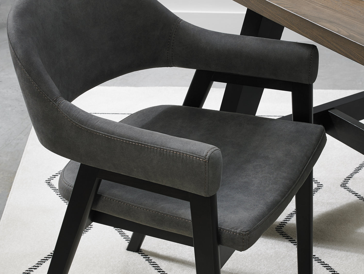 Up close view of the Candice Dark Grey Fabric Dining Chairs with Armrests and Oak Frame.