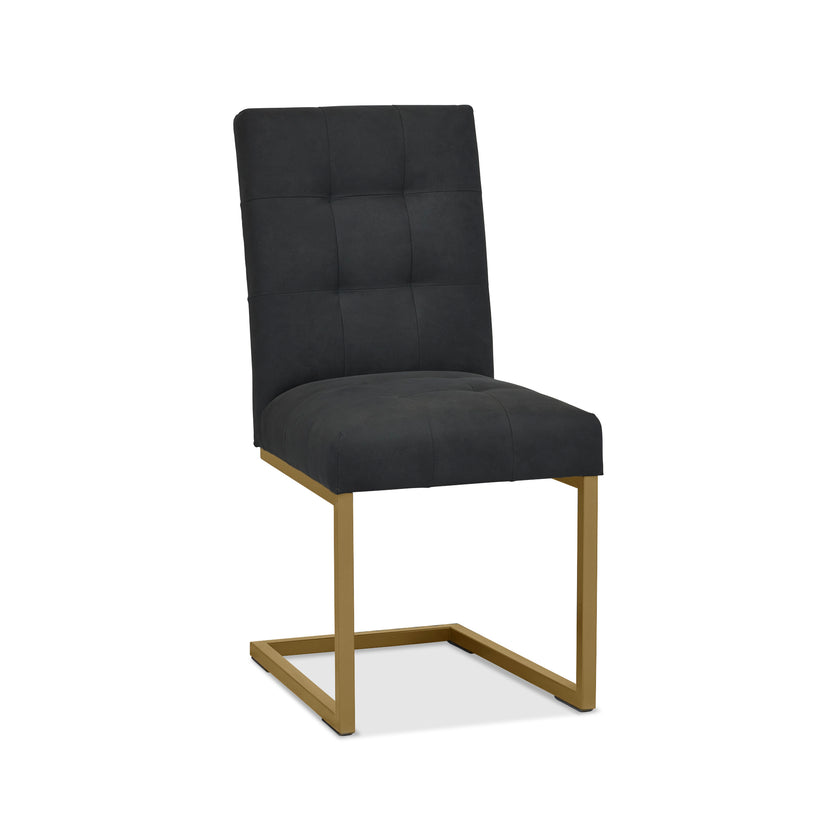 Front, angled and closer view of the Lindos Fabric Dining Chairs with black square-stitched upholstery and brass legs.
