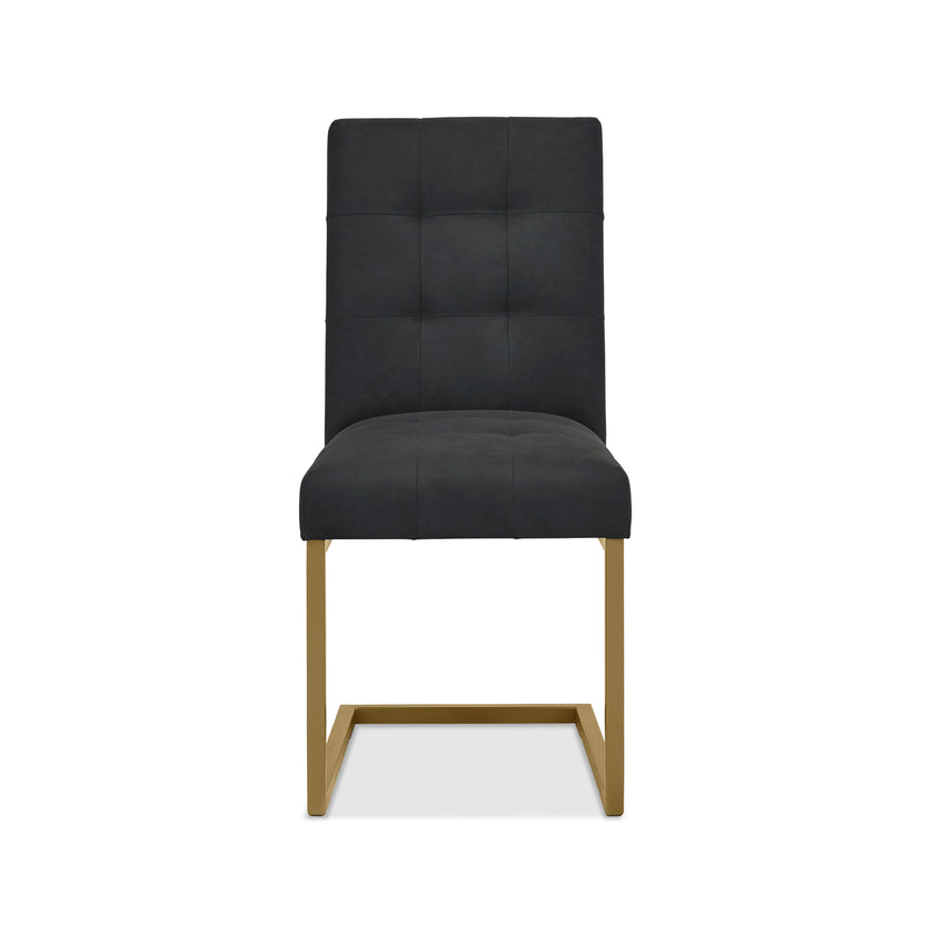 Front view of the Lindos Fabric Dining Chairs with black square-stitched upholstery and brass legs.
