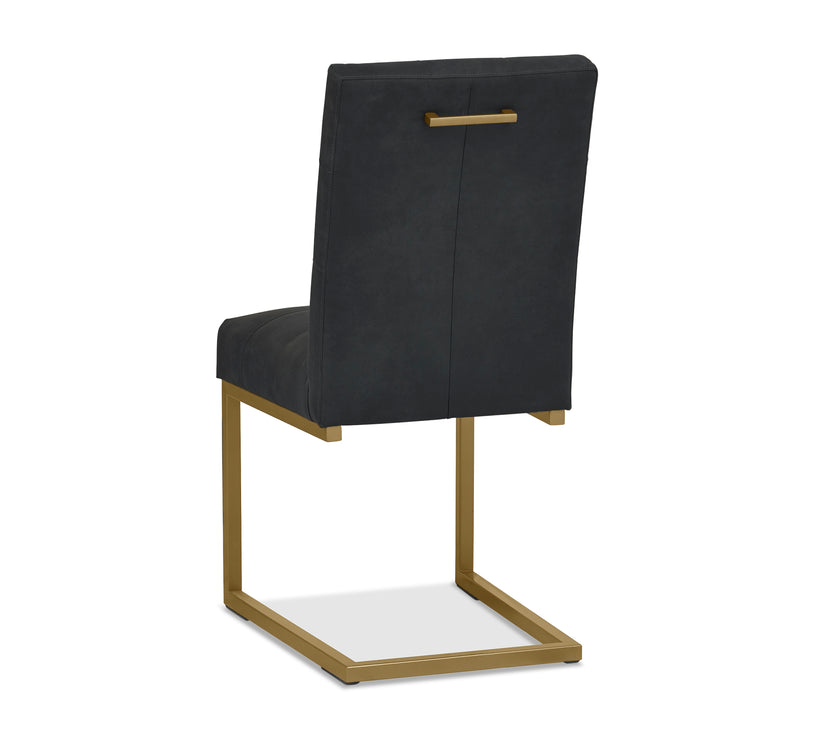 Angled and back image of the Lindos Fabric Dining Chairs with black square-stitched upholstery and brass legs.
