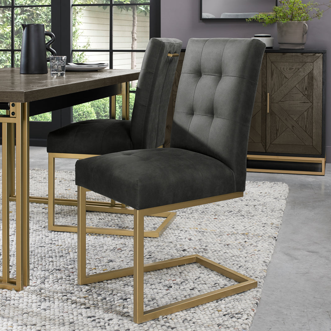 Angled view of the Lindos Fabric Dining Chairs with black square-stitched upholstery and brass legs.