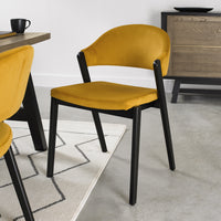 Angled and up close image pf the Candice Velvet Dining Chair with curved back and dark legs.