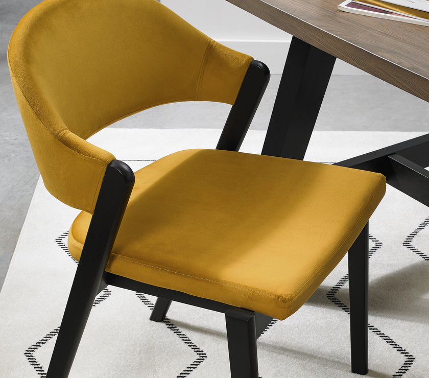 Close up image of the Candice Velvet Dining Chair with curved back and dark legs.