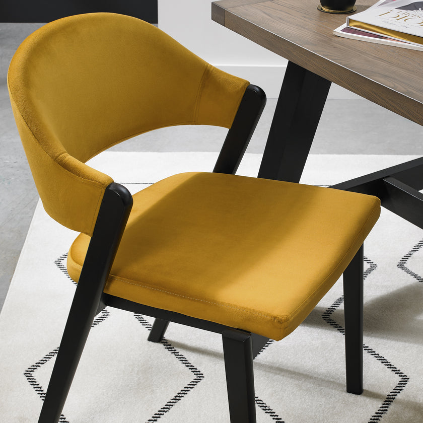 Close up image of the Candice Velvet Dining Chair with curved back and dark legs.