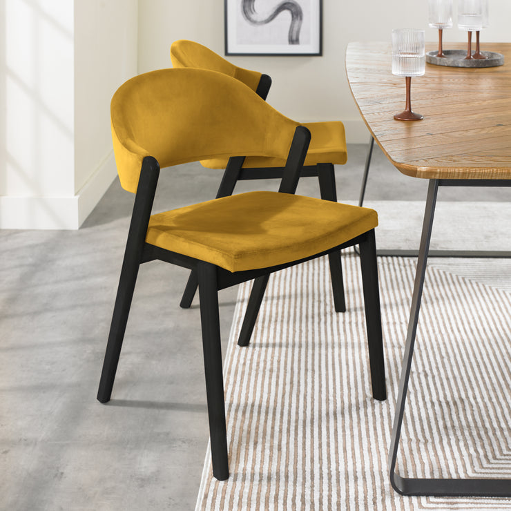 Angled Candice Velvet Dining Chair with curved back and dark legs.