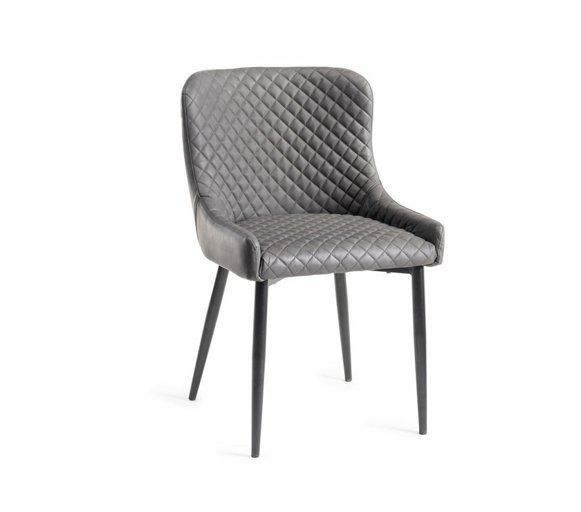 Angled image of the Lozanne Faux Leather Dining Chairs with diamond stitching and metal legs.