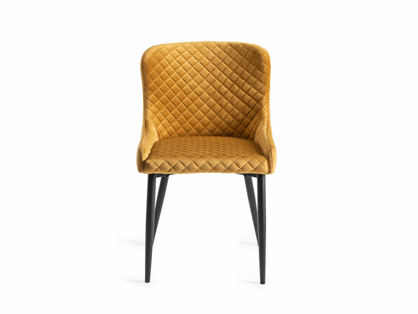 Front view of the Lozanne Velvet Dining Chair in mustard with diamond stitching and black legs.