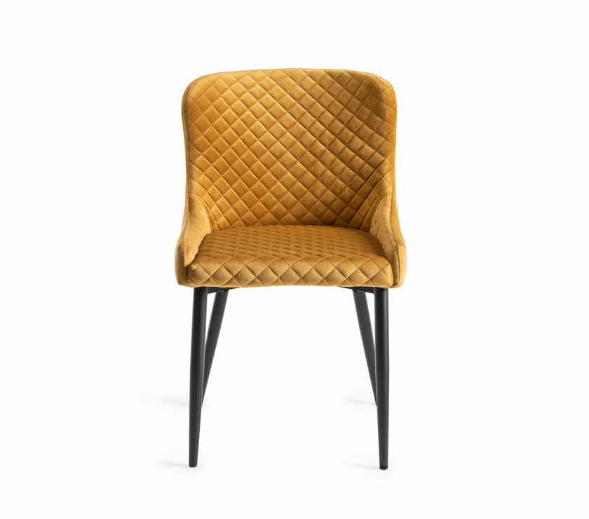 Front view of the Lozanne Velvet Dining Chair in mustard with diamond stitching and black legs.