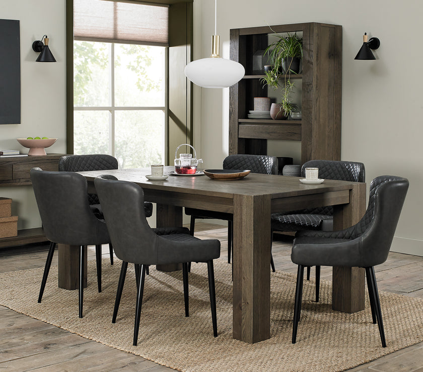 Image of the Lozanne Faux Leather Dining Chairs with diamond stitching and metal legs in a set with other chairs and a table.