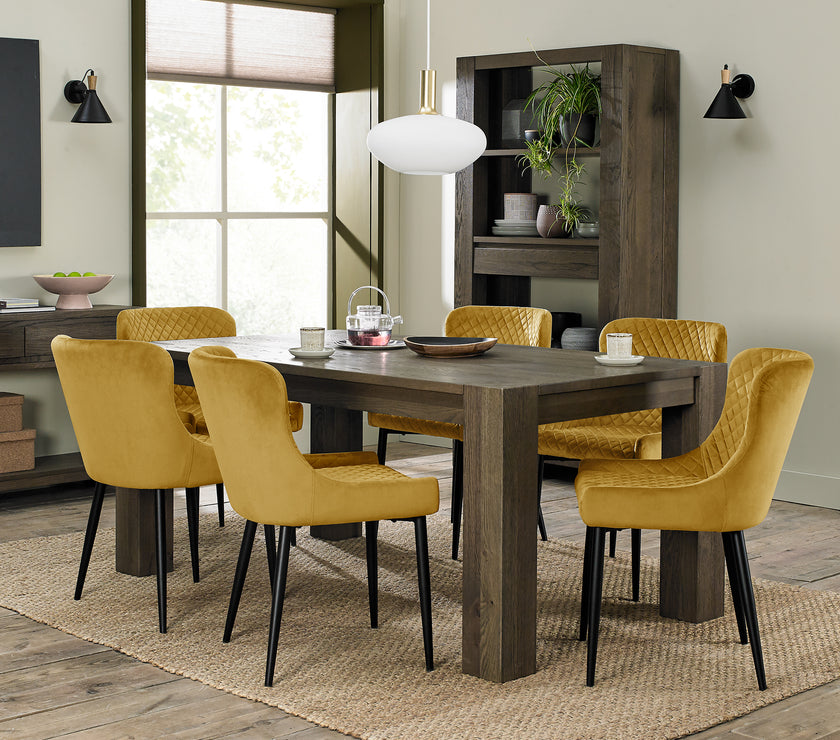 image of our Lozanne Velvet Dining Chairs in mustard with diamond stitching and black leg styled with one of our stunning dining tables
