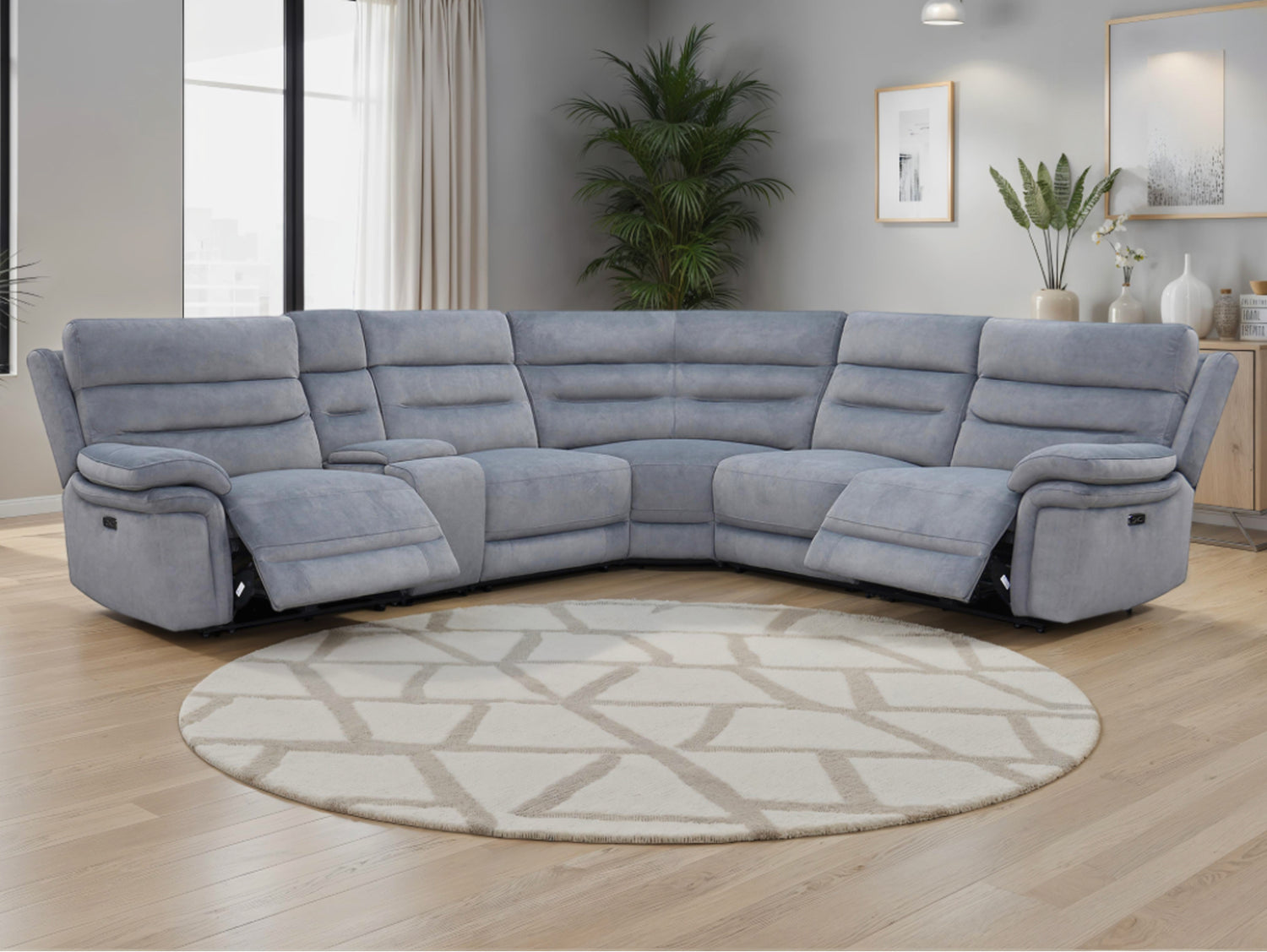 Grey recliner sofa in a living room with a round rug and décor elements.