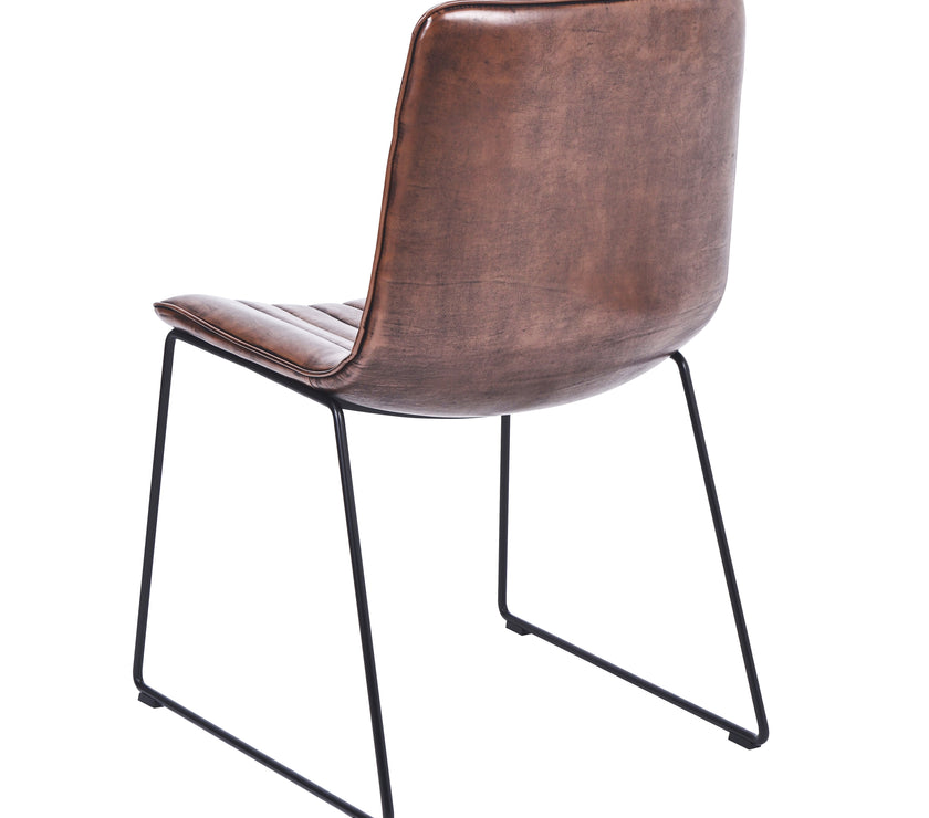 Back and angled view of the Atlas Faux Leather Dining Chairs with curved back, tan upholstery, and black metal legs.