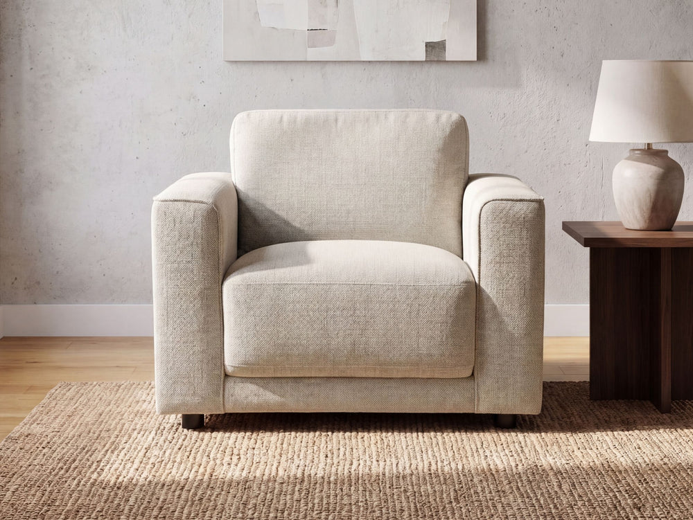 Esme armchair in a living room setting with a side table and lamp.