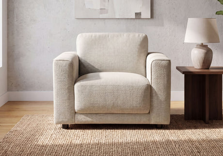 Esme armchair in a living room setting with a side table and lamp.