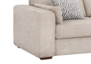 Close-up of a beige upholstered sofa corner with a patterned gray and white accent pillow on a white background.