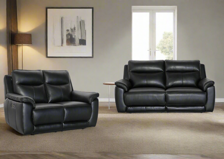 Black leather sofa set in a living room with a painting and window in the background.