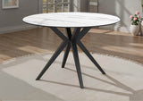 Round dining table with white ceramic top and black metal legs in a room setting.