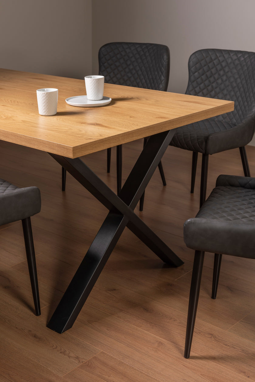 Side view of the Nancy Dining Table styled with black dining chairs.