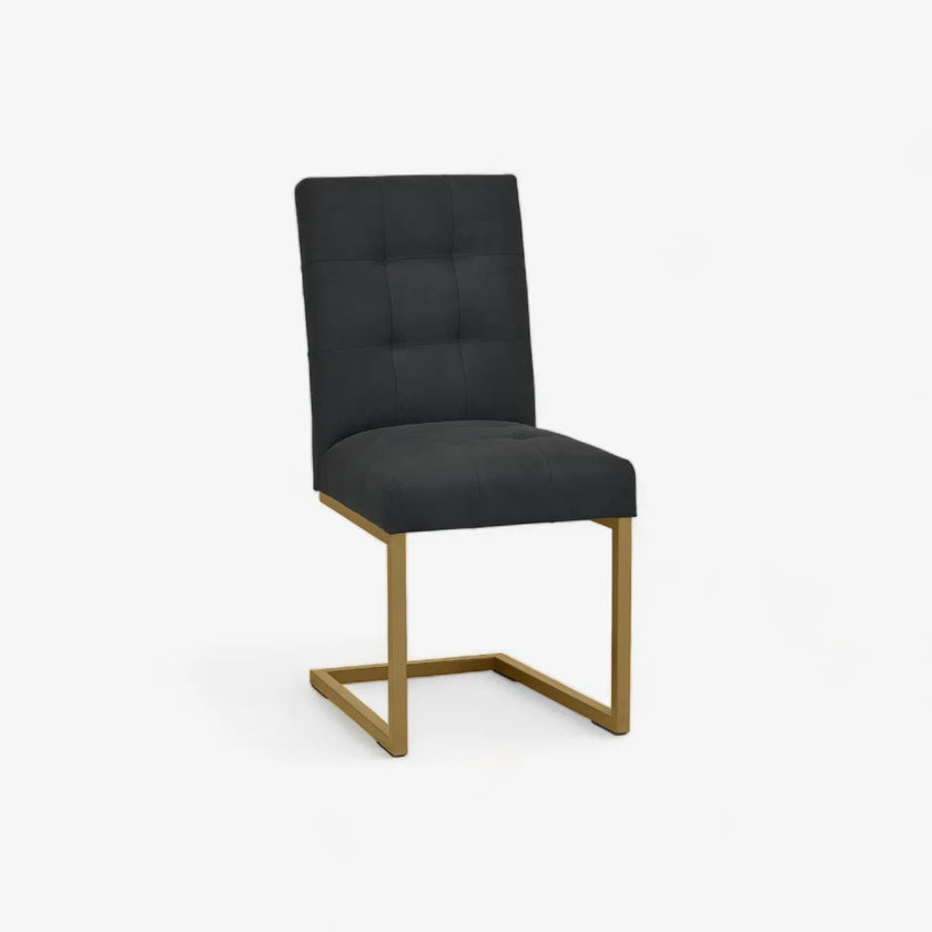 Angled and front view of the Lindos Fabric Dining Chairs with black square-stitched upholstery and brass legs.

