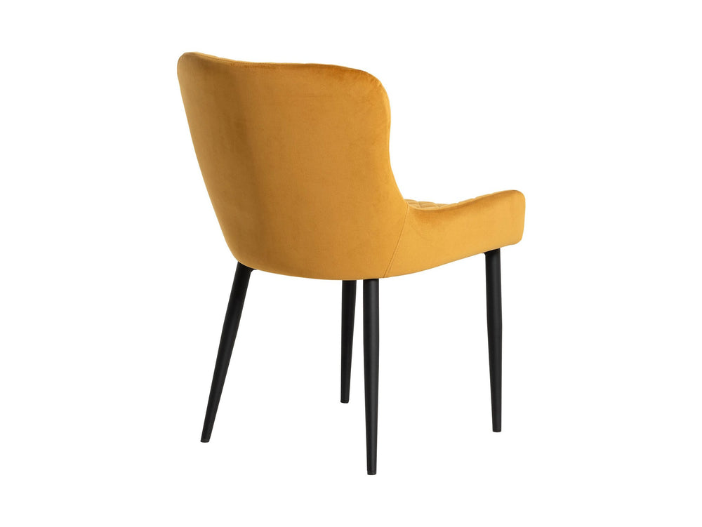 Back view of a mustard yellow velvet dining chair 