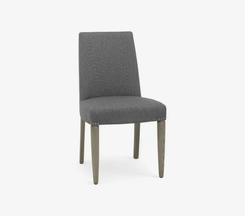 Front and angled view of the Marilyn Fabric Dining Chairs with slate grey upholstery and silver grey tapered legs.