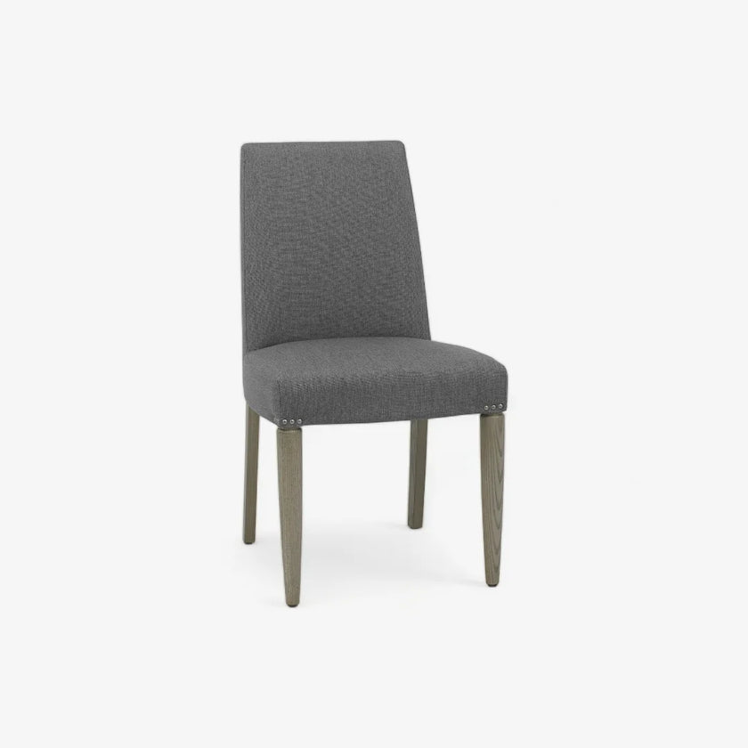 Front and angled view of the Marilyn Fabric Dining Chairs with slate grey upholstery and silver grey tapered legs.