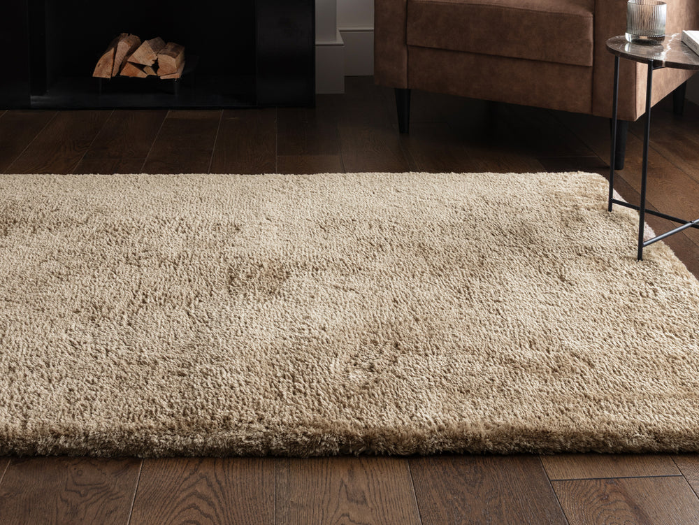 A taupe rug on a wooden floor.