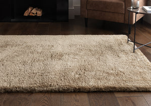 A taupe rug on a wooden floor.