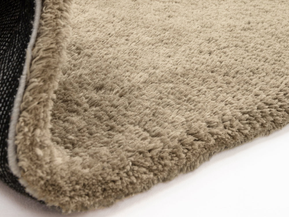 Close up of taupe rug on white background. 