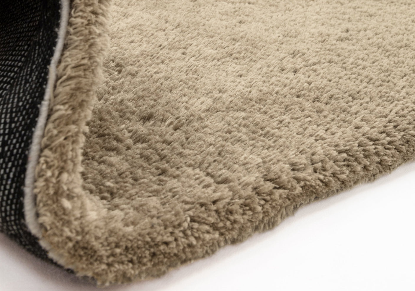 Close up of taupe rug on white background. 