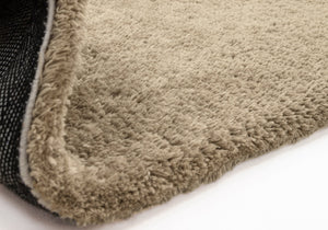 Close up of taupe rug on white background. 