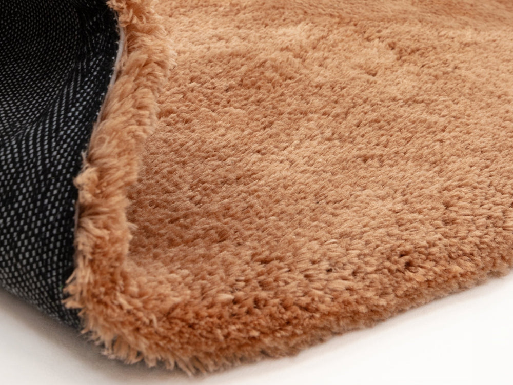 A close up of a terracotta rug on a white background.