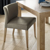 Angled view of the Turner Light Oak Dining Chairs with soft gold fabric and tapered light oak legs.