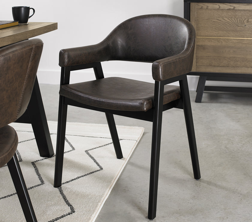 Angled view of the Candice Upholstered Dining Chairs with arm rests and oak frame.