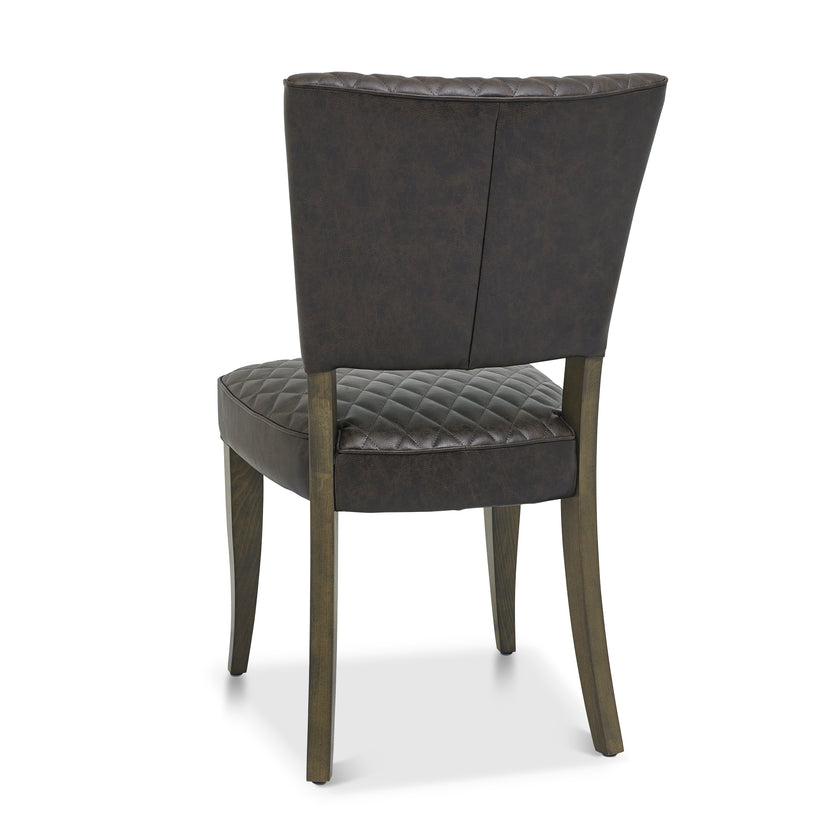 Back and angled Image of the Landon Fumed Oak Dining Chairs Saddle Faux Leather with dark oak frame styled with NCF's Dining Furniture.
