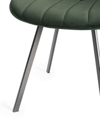 View of the legs of the Savio Dining Chairs in green velvet with vertical stitching and metal legs.