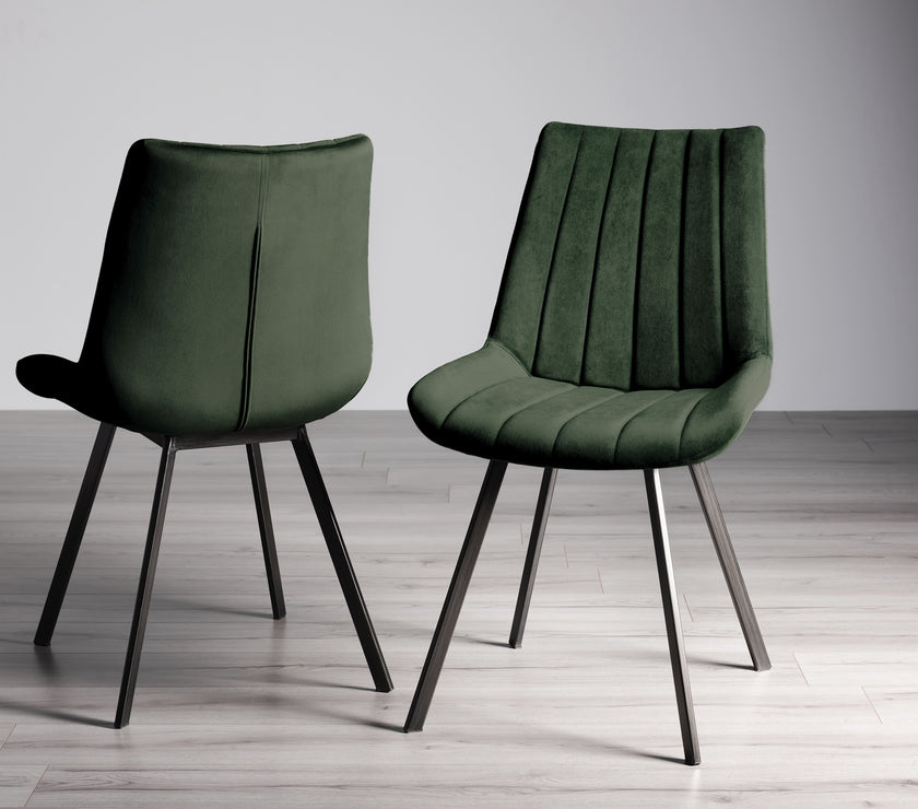 Image of the Savio Dining Chairs in green velvet with vertical stitching and metal legs.