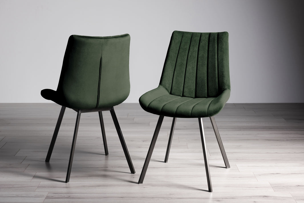 Image of the Savio Dining Chairs in green velvet with vertical stitching and metal legs.