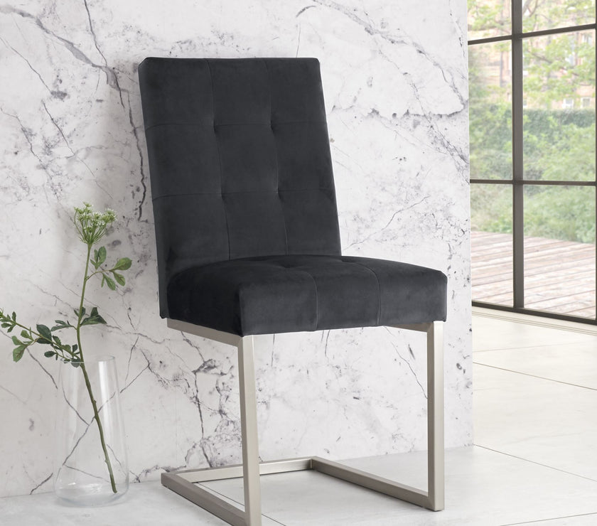 Angled and front view of the Toulouse Velvet Dining Chairs with gunmetal fabric, chrome cantilever frame, and quilted button detailing.