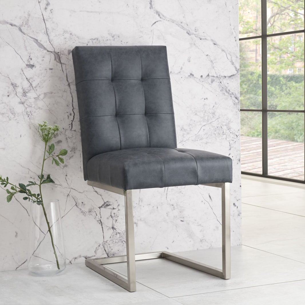 Front view of the Toulouse Cantilever Faux Leather Dining Chairs with dark oiled oak, black oak accents, and satin nickel frame.