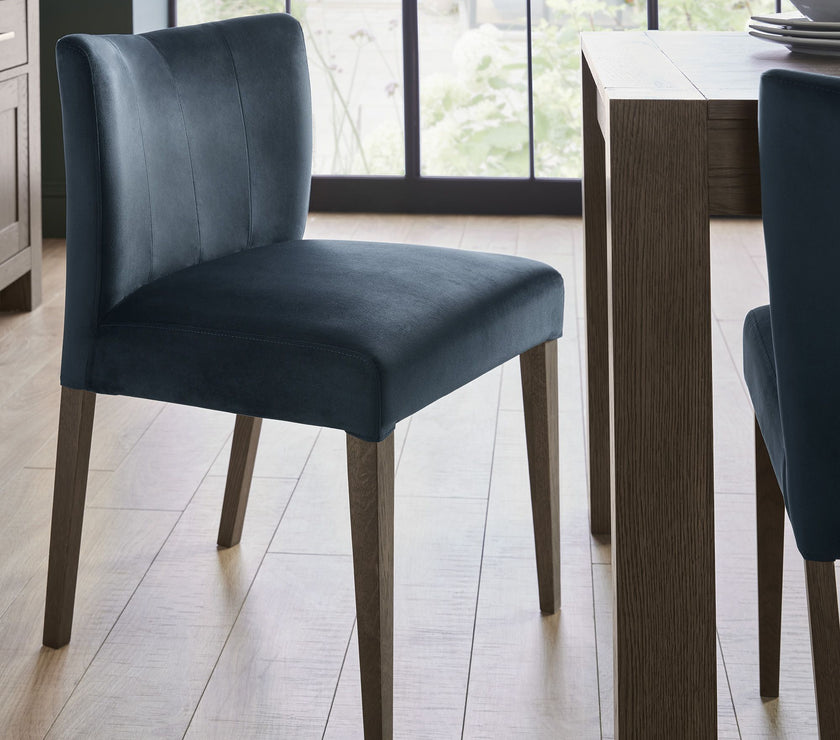 Angled image of the Turner Dark Oak Dining Chairs with foam cushion, fabric upholstery, and tapered dark oak legs.